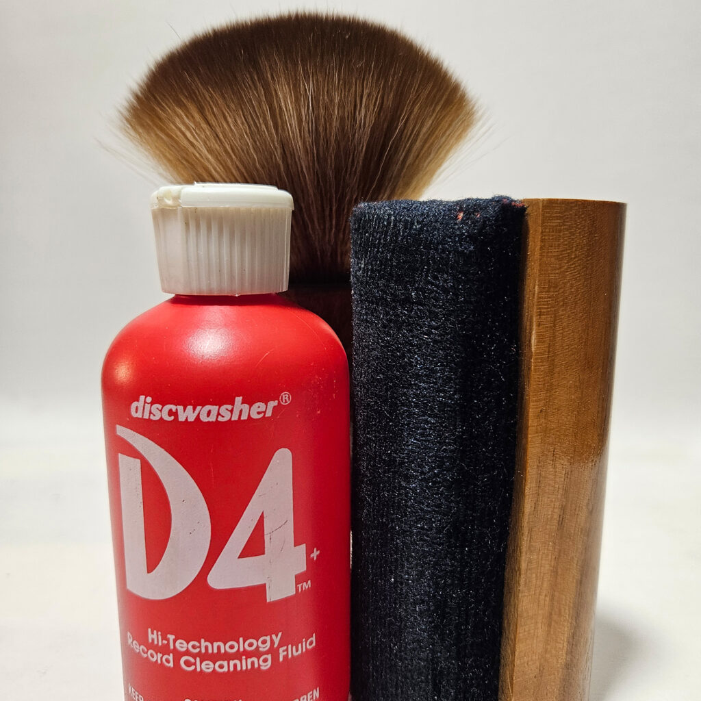 Vinyl record cleaning setup with brush and cleaning solution on a record